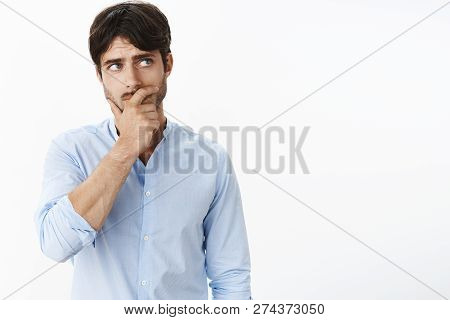 Concerned Young Good-looking Mature Husband With Blue Eyes And Bristle Holding Hand On Jaw, Frowning