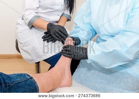 Podology Treatment. Podiatrist Treats Foot. Podiatry Doctor Or Dermatologist Treats The Patient In M