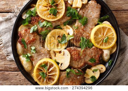 Italian Veal Scaloppini With Mushrooms And Lemons In A Sauce Close-up In A Frying Pan. Horizontal To