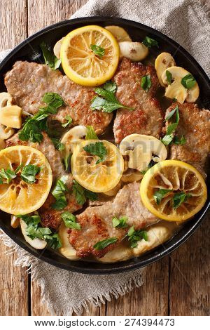 Italian Veal Scaloppini With Mushrooms And Lemons In A Sauce Close-up In A Frying Pan. Vertical Top
