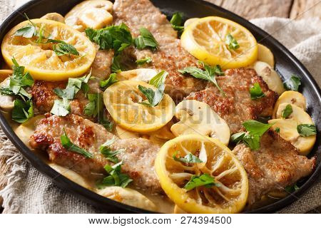 Scaloppini Veal Cooked With Mushrooms And Lemons In A Spicy Sauce Close-up In A Frying Pan. Horizont