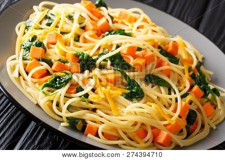 Delicious Italian Food Spaghetti With Pumpkin, Spinach And Cheddar Cheese Close-up On A Plate. Horiz
