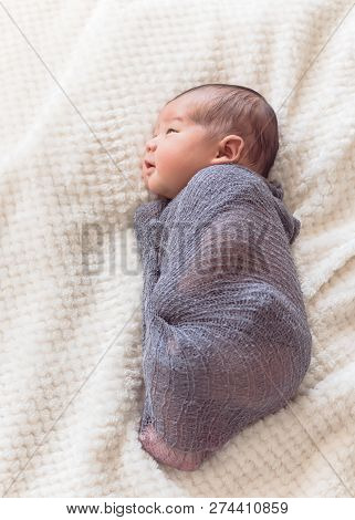 Smiling Asian Newborn Baby Boy In Mohair Wrap