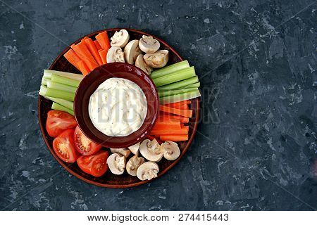 Vegetable Tray With A Ranch Dip On A Dark Background. Raw Vegetable Mix Includes Sliced Mushrooms, C