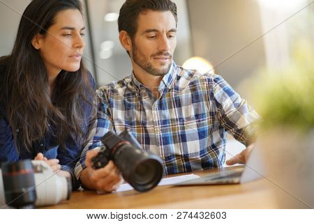 Photographer colleagues going through photos on camera