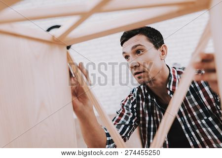 Young Man Assembling Wooden Bookshelf At Home. Wooden Bookcase. Selfmade Furniture. Man And Hobby. W