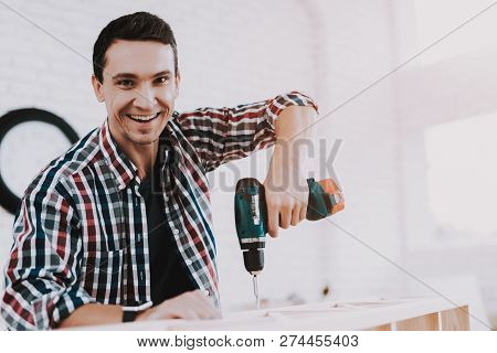 Young Man Assembling Wooden Bookshelf At Home. Wooden Bookcase. Selfmade Furniture. Man And Hobby. W