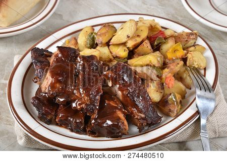 Delicious Barbecue Beef Ribs With Roasted Potato Wedges And Vegetabes