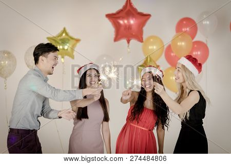 Diversity Of Young People Have Fun And Liten Sparklers At Christmas And New Year Party, Background O