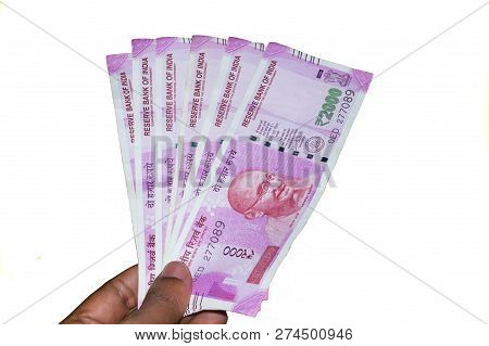 Selective Focus: Hand Holding Indian 2000 Rupee Notes Against White Background. Close Up Of The New 