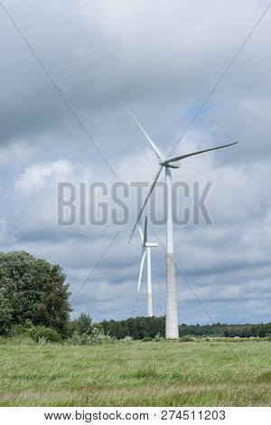 Ecology Concept: Blue Sky, White Clouds, Wind Turbine And Crop Field. Wind Generator For Electricity