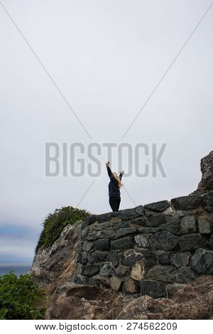 Blonde Adult Woman In Patrick's Point State Park Raising Her Arms In Joy In Wedding Rock In Northern