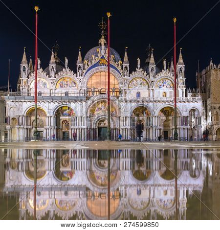 Basilica in San Marco square in Venice with reflection at night during the high tide, or aqua alta, that flooded the square with sea water