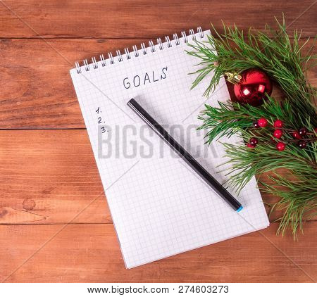 Notepad For Writing Resolution And Goals For The New Year, Spruce Branches On A Wooden Background Wi