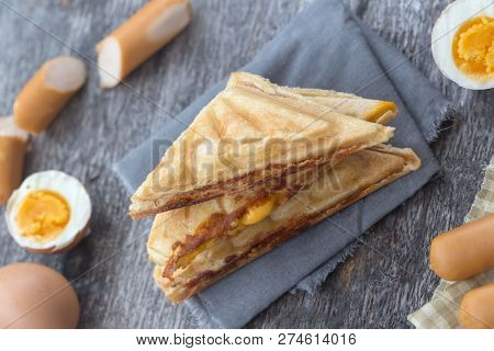 Pressed And Toasted Double Panini With Ham And Cheese Served On Sandwich Paper On A Wooden Table,egg