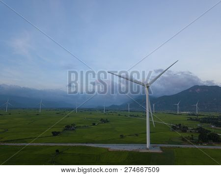 Wind Turbine Farm Or Windmill On Blue Sky. Turbine Green Energy Electricity Or Wind Turbine In A Gre