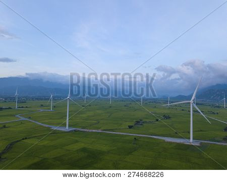 Wind Turbine Farm Or Windmill On Blue Sky. Turbine Green Energy Electricity Or Wind Turbine In A Gre