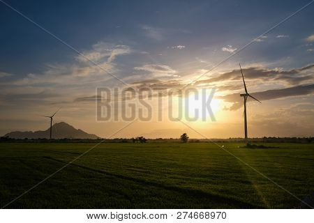 Wind Turbine Farm Or Windmill On Blue Sky. Turbine Green Energy Electricity Or Wind Turbine In A Gre