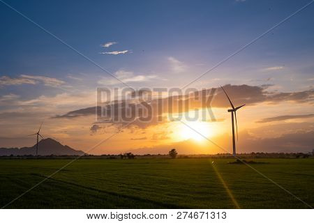 Wind Turbines Farm And Agricultural Fields On Blue Sky. Turbine Green Energy Electricity Or Wind Tur