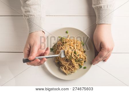 Spaghetti On White Plate. Fusion Cuisine Food Style. A Female Hand Is Trying To Use Fork To Eat.