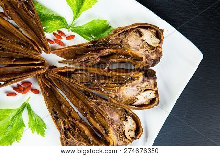 Duck Head With Marinated Sauce On The White Dish