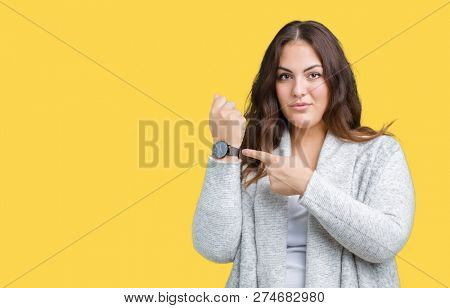 Beautiful plus size young woman wearing winter jacket over isolated background In hurry pointing to watch time, impatience, upset and angry for deadline delay