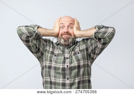 Tensed Mature European Man Covering Ears Trying Not To Listen His Girlfriend