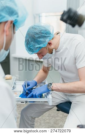 Doctor Used Microscope. Dentist Is Treating Patient In Modern Dental Office. Operation Is Carried Ou