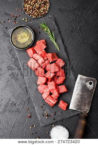 Raw Lean Diced Casserole Beef Pork Steak On Chopping Board With Vintage Meat Hatchet On Stone Backgr