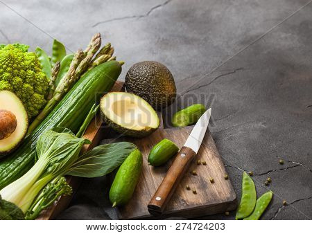 Assorted Green Toned Raw Organic Vegetables In Wooden Box On Dark Stone Background. Avocado, Cabbage