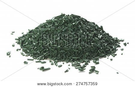 Close Up Of Organic Spirulina Flakes Heap Over White Background.