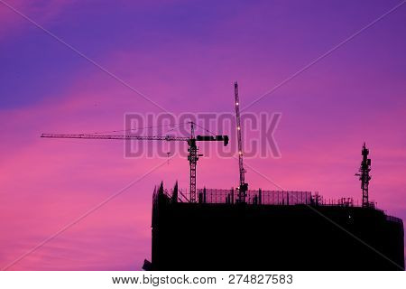 Crane And Building Construction Site At Sunset. High-quality Stock Photo Image Silhouette Of Constru
