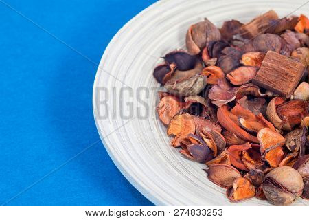 Potpourri In The Wooden Plate. Close Up. Blue Background.
