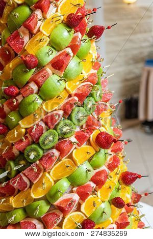 Tropical Fruits Cut Thtower Of Chopped Tropical Fruits And Strawberries At The Banquet. Appetizer At