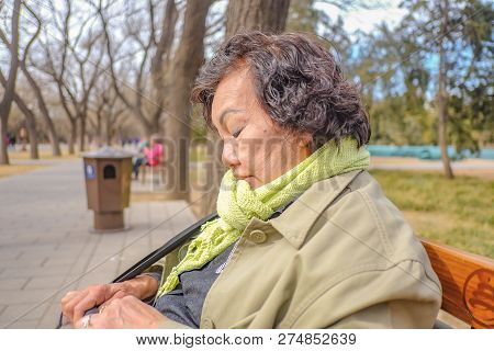 Portrait Photo Of Senior Asian Women Traveler Sitting And Relax In Temple Of Heaven Park Or Tiantan 