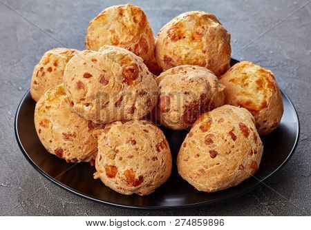 Delicious Crispy Gougeres, Cheese Puffs Balls On A Black Plate. Traditional French Cheese Choux Buns