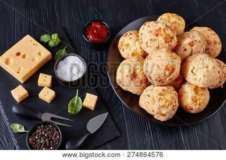 Gougeres, Cheese Puffs Balls On A Black Plate. Traditional French Cheese Choux Buns. Cheese And Toma