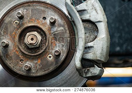 Close-up Of The Replacement Of The Old Front Brake Disc, Brake Caliper And Hub Nut On A Car Lifted O