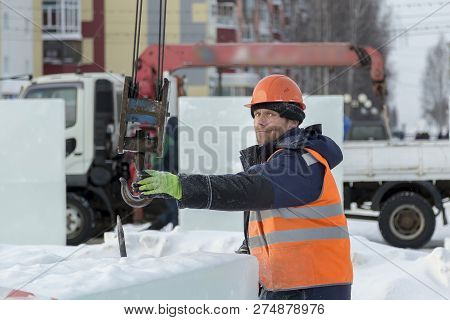 Slinger In An Orange Helmet On Unloading Ice Blocks