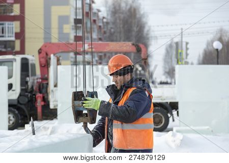 Slinger In An Orange Helmet On Unloading Ice Blocks