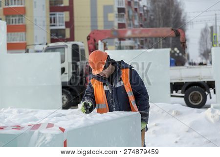 Slinger In An Orange Helmet On Unloading Ice Blocks