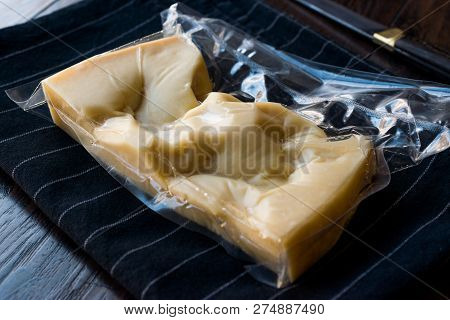 Turkish Traditional Gravyer / Gruyere Cheese In Package From Kars On Wooden Surface.