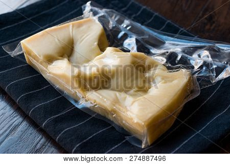 Turkish Traditional Gravyer / Gruyere Cheese In Package From Kars On Wooden Surface.