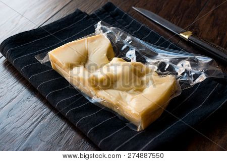 Turkish Traditional Gravyer / Gruyere Cheese In Package From Kars On Wooden Surface.
