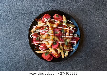 Homemade Peruvian Salchipapa Fries With Sausage Slices, Ketchup And Mayonnaise.