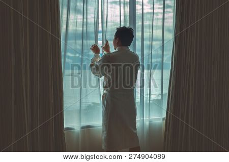 Asian Man In Bathrobe Suit Opening And Sightseeing The Sea Beach When Waking Up From The Bed In Luxu