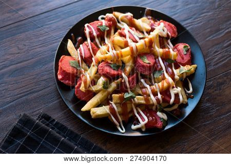 Homemade Peruvian Salchipapa Fries With Sausage Slices, Ketchup And Mayonnaise.