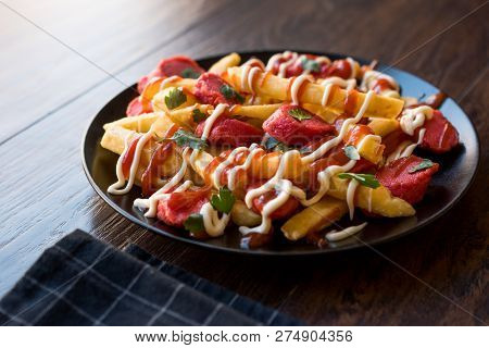 Homemade Peruvian Salchipapa Fries With Sausage Slices, Ketchup And Mayonnaise.