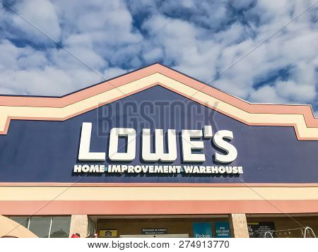 Close-up Logo Of Lowe’s Hardware Store Entrance Under Cloud Blue Sky
