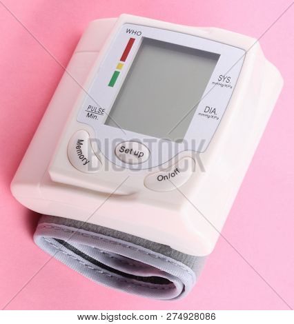 Automatic Wrist Digital Blood Pressure Monitor On Pink Background At Dry Day